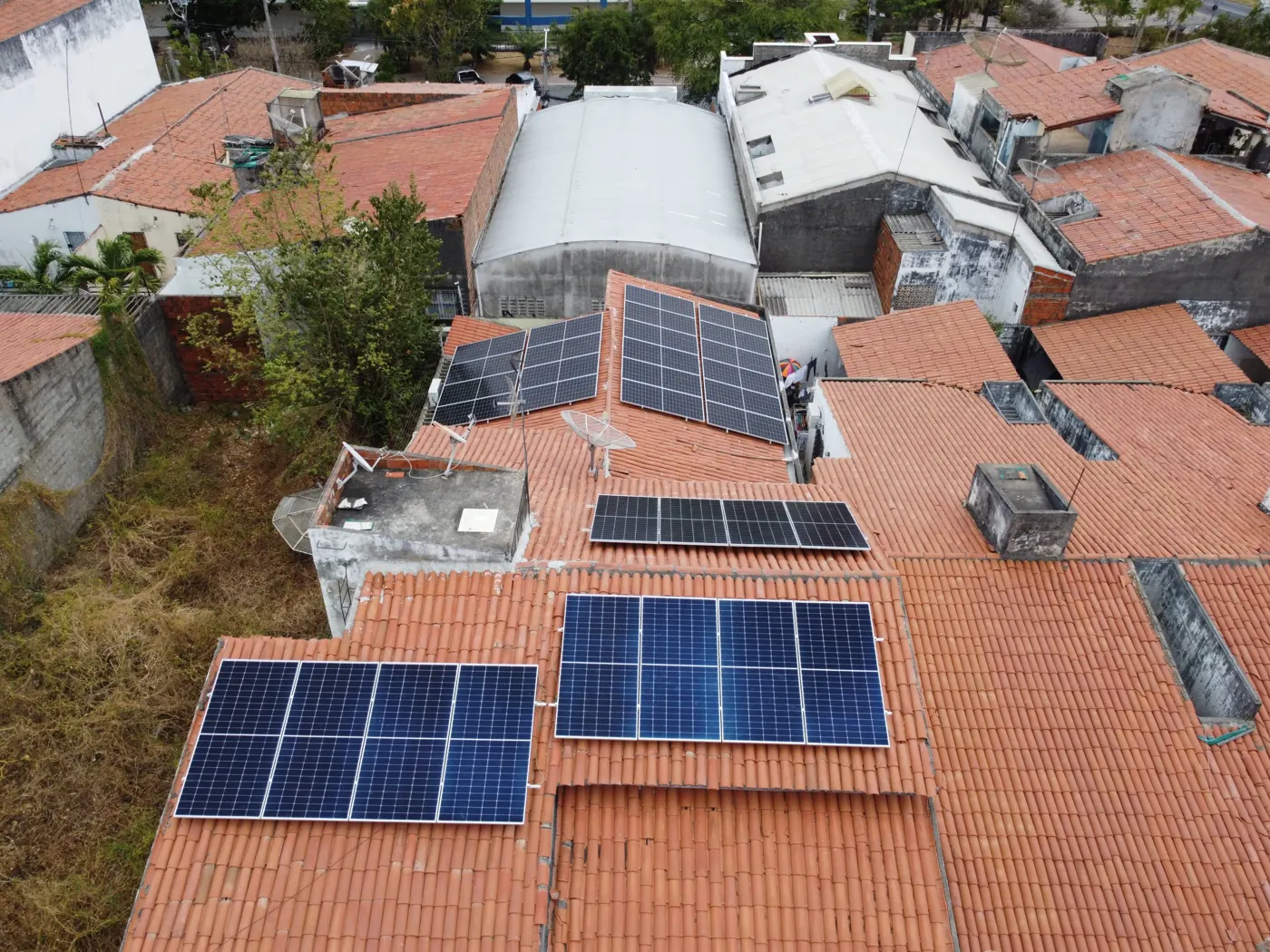 Vista aérea de placas solares instaladas em diferentes águas de um telhado residencial